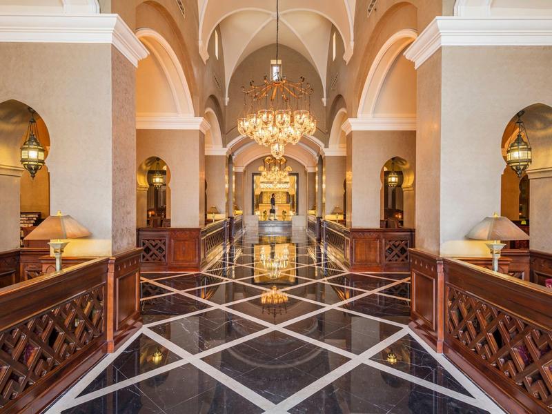 Elegante Hotellobby mit hohen Gewölbedecken, Kronleuchtern und glänzendem Marmorboden.