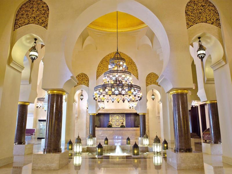 Prächtiger Innenraum mit kunstvollen Bögen, Kronleuchtern und Säulen in einem Luxushotel