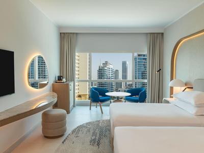 Modernes Hotelzimmer mit Bett, Fensterblick auf Stadt und elegantem Interieur.