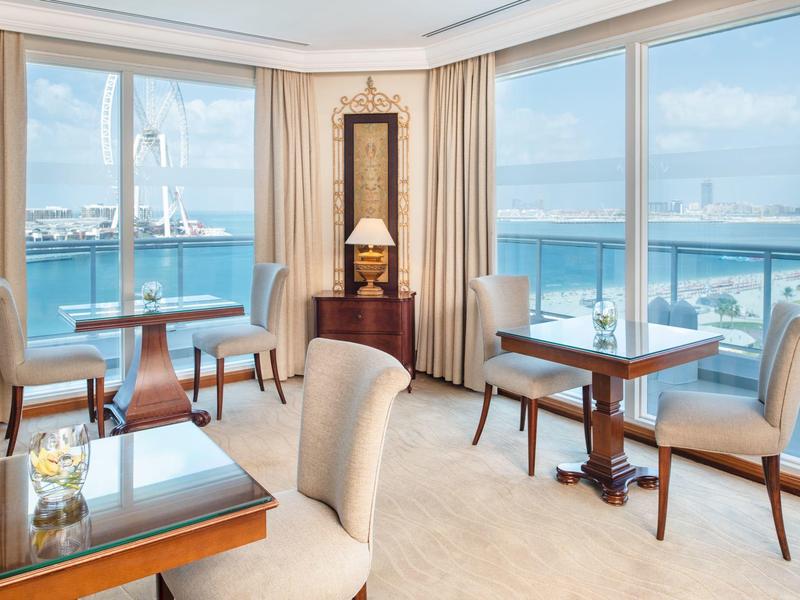 Eleganter Hotel-Loungebereich mit großen Fenstern und Blick auf Wasser und Boote.