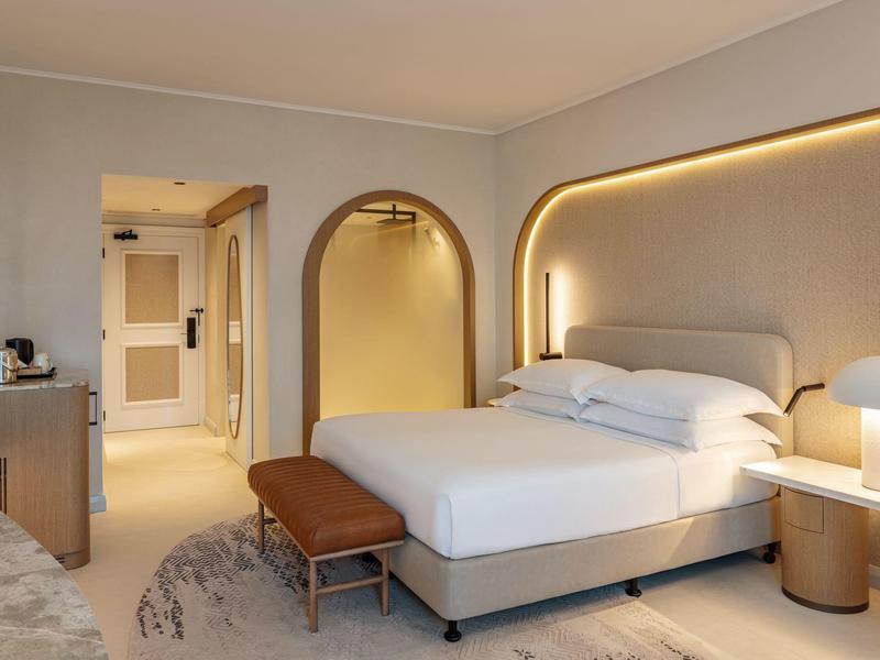 Modernes Hotelzimmer mit großem Bett, Nachttischen und warmem Licht