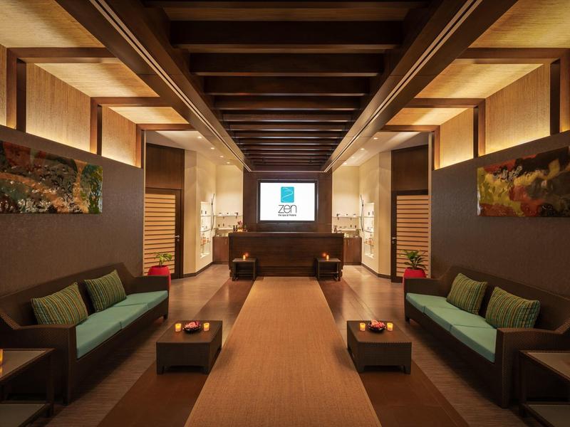 Einladender Raum mit Holzbalkendecke, modernen Sofas und warm beleuchteter Atmosphäre.