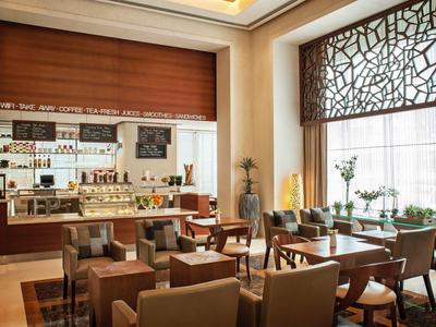 Modernes Restaurant mit elegantem Interieur und großen Fenstern, das Tageslicht hereinlässt.