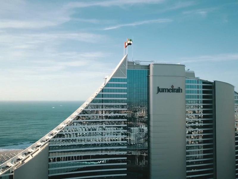 Moderner Hochhauskomplex am Meer bei klarem Himmel mit Glasfassaden und markanter Architektur.