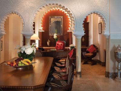 Eleganter Raum mit orientalischen Bogen, Holzmöbeln und dekorativer Beleuchtung.