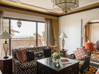 Elegantes Wohnzimmer mit gemusterten Sofas, zwei Lampen, einem Tisch und dekorativen Kissen.