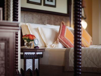 Ein gemütliches Hotelzimmer mit einem dekorativen Tisch, Blumen und Kissen auf dem Bett.