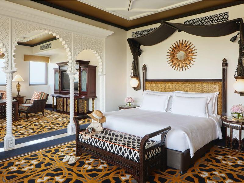 Elegantes Schlafzimmer mit großem Bett, hellen Holzmöbeln und dekorativem Teppich.