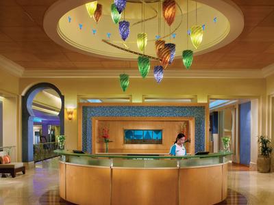 Rezeption mit rundem Schreibtisch und bunten Hängelampen in einem modernen Hotel