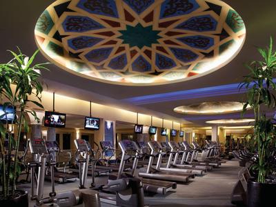 Moderne Fitnessstudio mit Laufbändern und dekorativer, beleuchteter Decke mit orientalischem Muster.