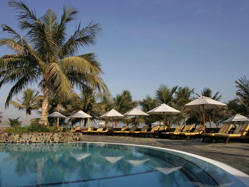 Zwei Männer auf einem Golfplatz, einer sitzt im Golfwagen, der andere steht mit Golfschläger.