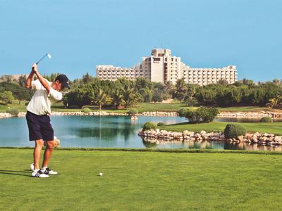 Bunter, großer Wasserspielplatz mit Rutschen und Wasserspritzern unter blauem Himmel.