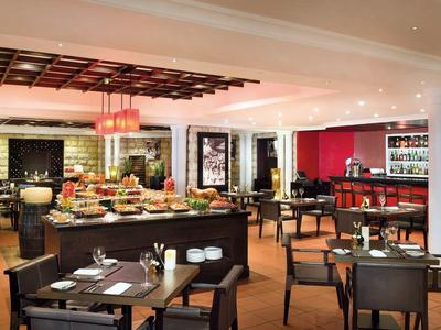 Restaurante moderno y acogedor con lámparas redondas, techo de madera y mesas preparadas.