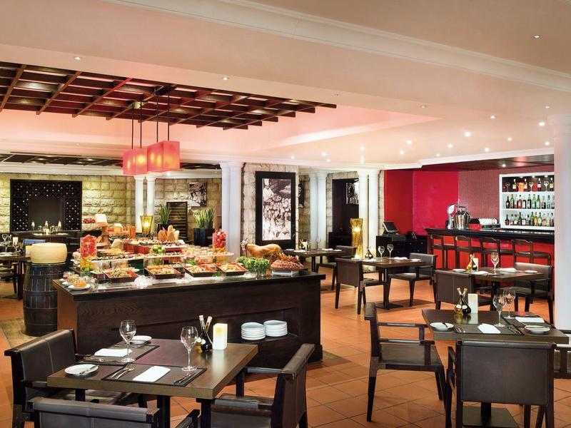 Restaurante moderno y acogedor con lámparas redondas, techo de madera y mesas preparadas.