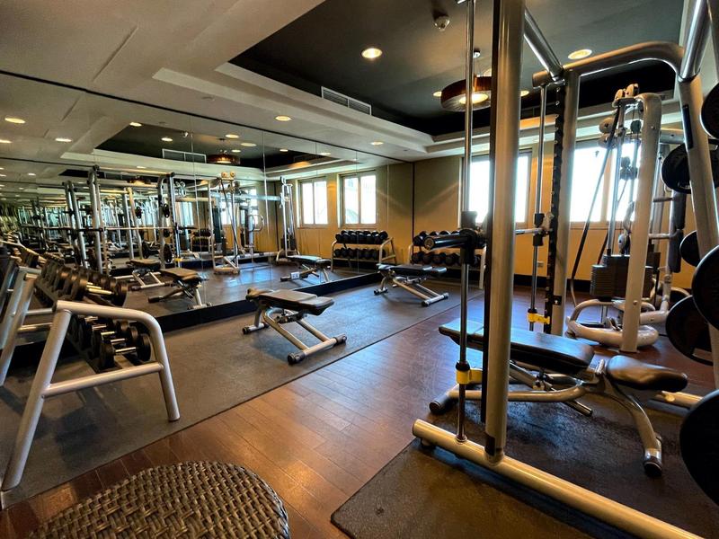 Interior de un gimnasio bien equipado con máquinas y espejos.