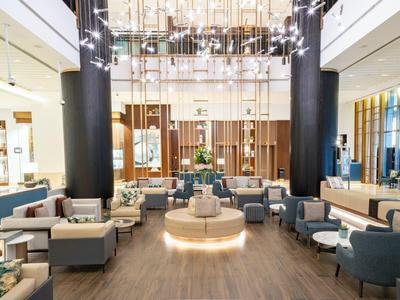Großer, moderner Hotellobby-Bereich mit Sitzgruppen und beleuchtetem zentralem Sitz.