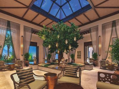 Großer Raum mit Glaskuppel, Pflanzen und gemütlichen Sitzgruppen in warmem Licht.