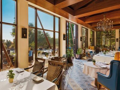 Elegantes Hotelrestaurant mit großen Fenstern und modernem Interieur mit Holzbalken.
