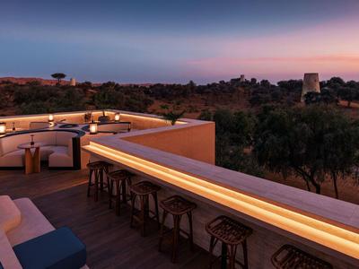 Luxuriöse Hotelterrasse mit stilvollen Sitzbereichen und Blick auf die Landschaft bei Sonnenuntergang.