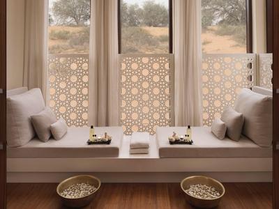 Gemütliche Fensterbank mit Kissen und arabisch inspirierten Sichtschutz-Elementen in warmen Tönen.