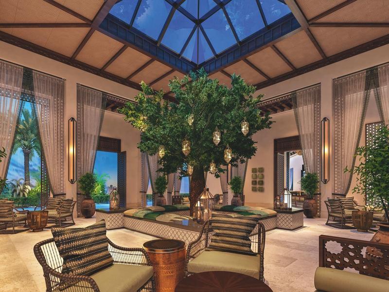 Großer Raum mit Glaskuppel, Pflanzen und gemütlichen Sitzgruppen in warmem Licht.