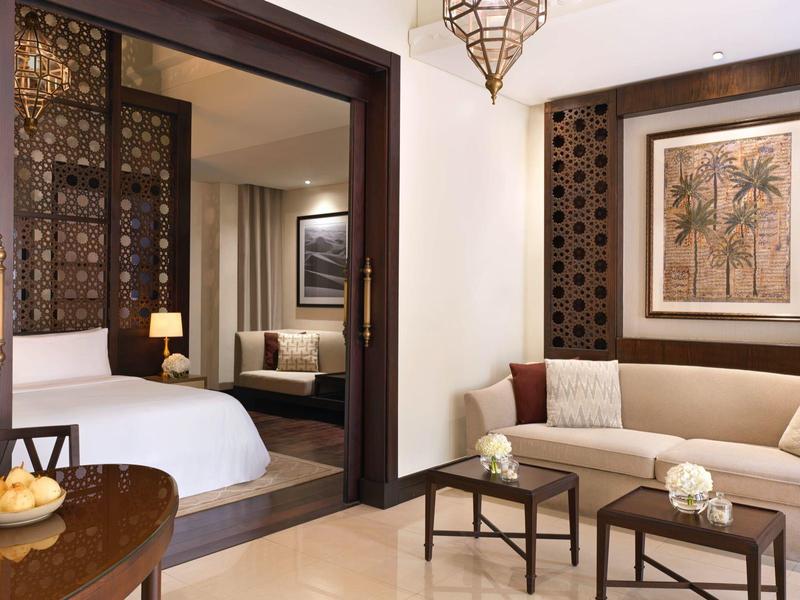 Elegantes Hotelzimmer mit großem Bett, Sofa und warmem Ambiente.