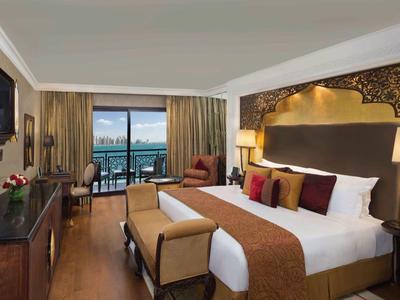 Elegantes Hotelzimmer mit Kingsize-Bett, Balkon mit Meerblick und moderner Einrichtung.