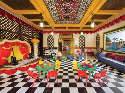 Bunt eingerichteter Kinderspielraum mit bunten Tischen und Stühlen und orientalischer Dekoration.