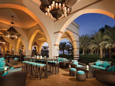 Luksusowy salon hotelowy z łukową architekturą, żyrandolami i wygodnymi miejscami do siedzenia.