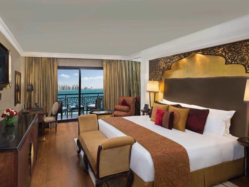 Elegantes Hotelzimmer mit Kingsize-Bett, Balkon mit Meerblick und moderner Einrichtung.