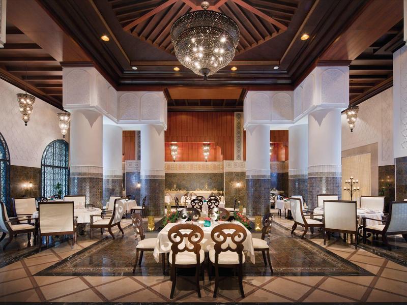 Eleganter Hotel-Lobby mit hohen Decken, Säulen und stilvollen Sitzbereichen.