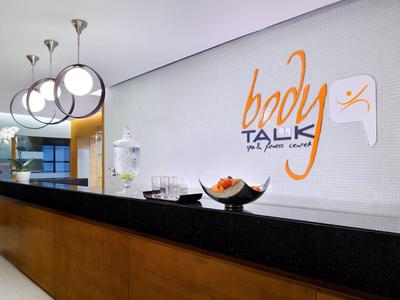 Réception d'hôtel moderne avec comptoir noir et lampes sphériques élégantes au plafond.