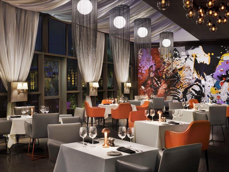 Restaurant élégant avec nappes blanches, art moderne et éclairage au plafond la nuit.