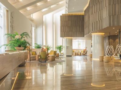 Bright, modern hotel lobby area with stylish furniture and large windows.