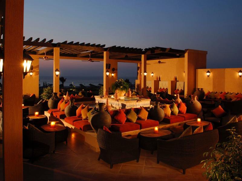 Espace extérieur cosy avec sièges et lumières au crépuscule dans un hôtel.