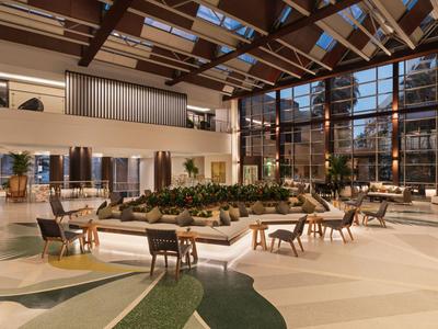 Helles Hotel-Lobby mit modernem Design, vielen Sitzgelegenheiten und großen Fensterfronten.