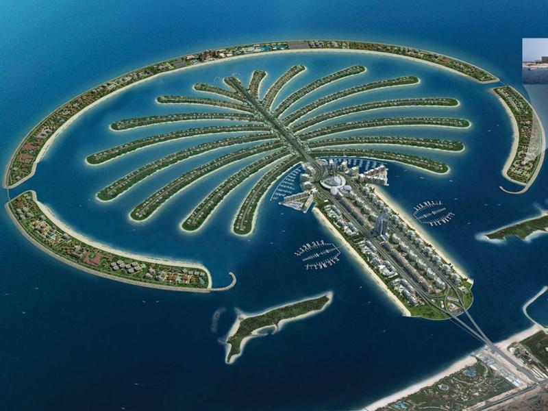 Luftaufnahme von Dubai mit der künstlichen Insel in Palmenform, umgeben von türkisfarbenem Wasser.
