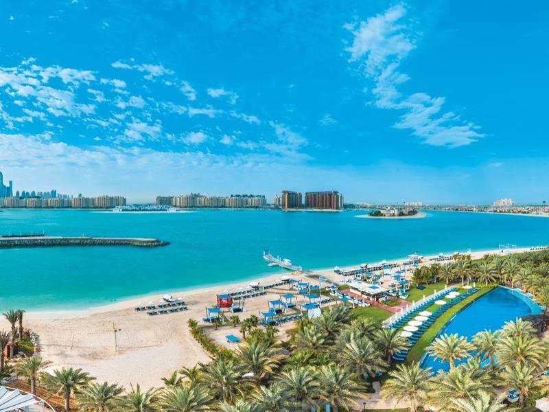 Panoramablick auf eine Küstenstadt mit Strand, in der Nähe von modernen Gebäuden und klarem blauen Wasser.