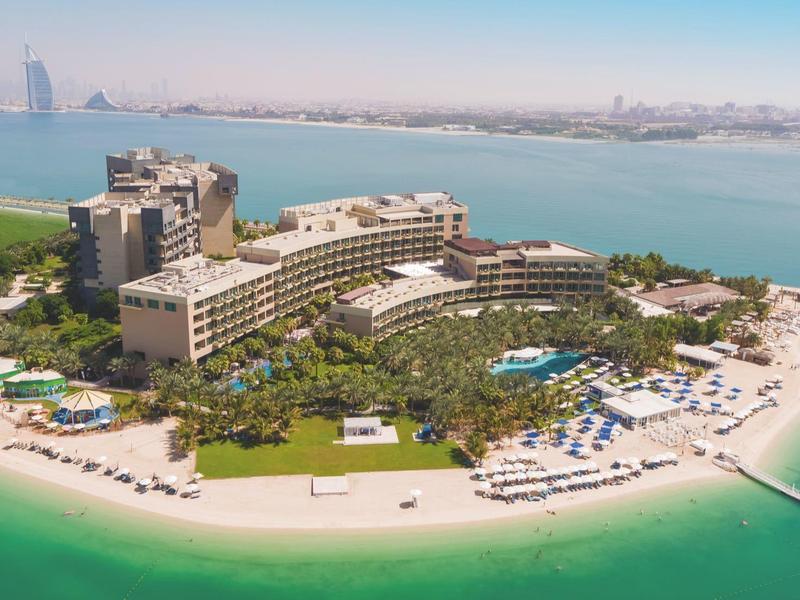 Luxushotel auf einer grünen Halbinsel mit Strand und Blick auf die Stadt und das Meer.