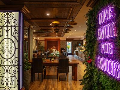 Elegant hotel lobby area with wooden flooring, decor, and glowing neon sign on the wall.