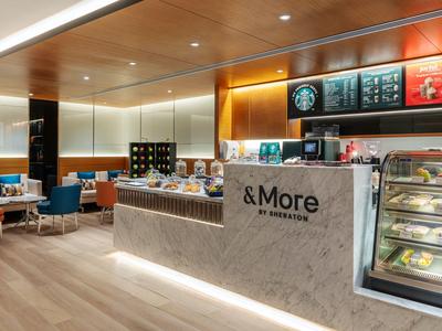 Modern café with light wood furniture and counter in a hotel.