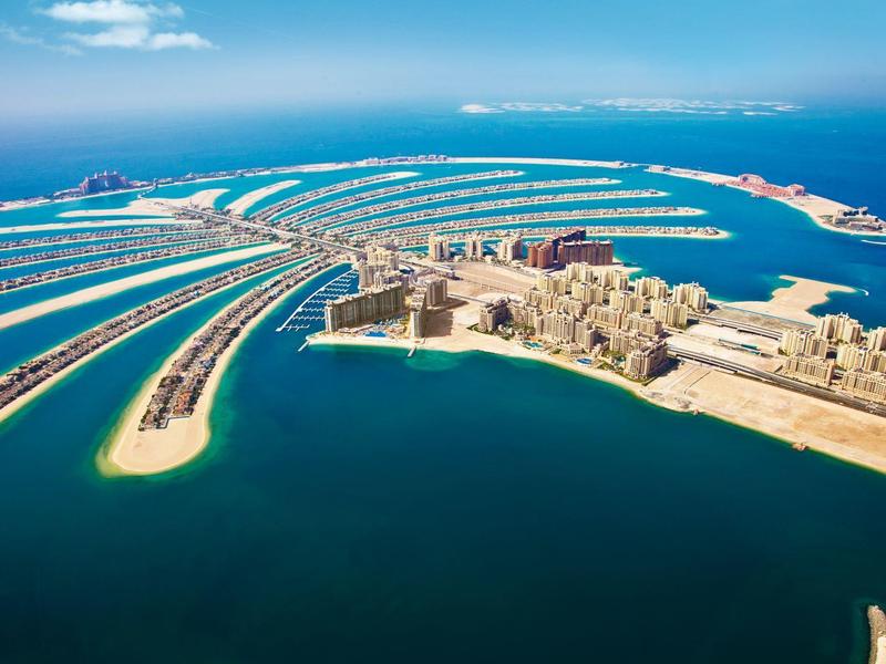 Luftaufnahme der künstlichen Insel The Palm Jumeirah in Dubai mit Hotels und dem Meer.