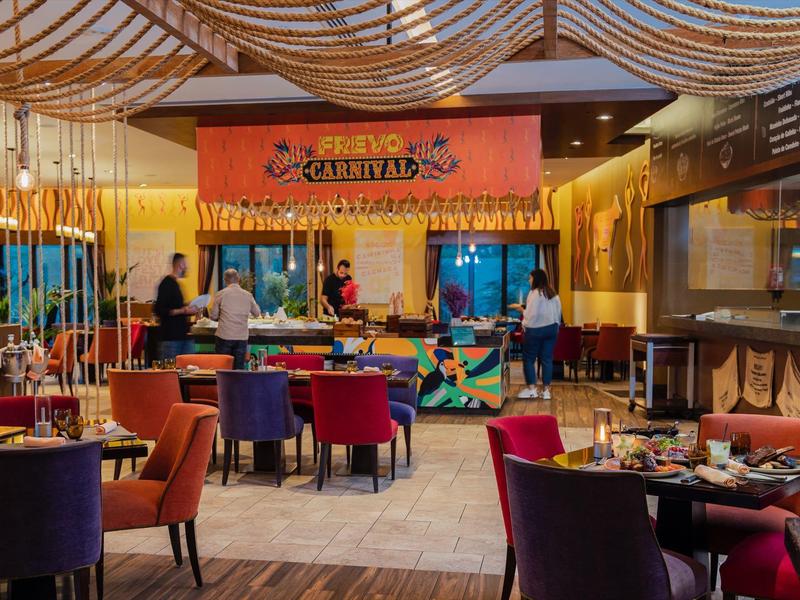 Bunte Bar mit Tischen und Stühlen in einem modernen Restaurantambiente.