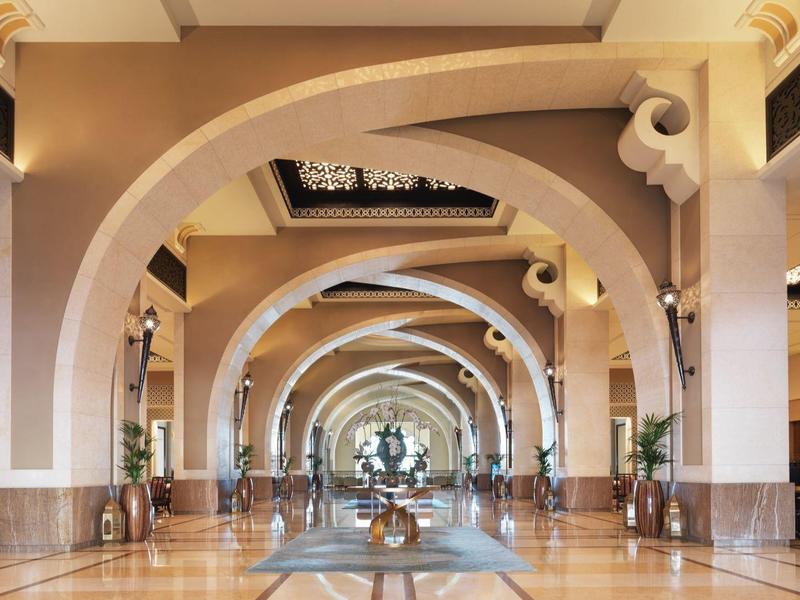 Großer Hotellobby-Bereich mit hohen Bögen und Pflanzen in langen Fluren.