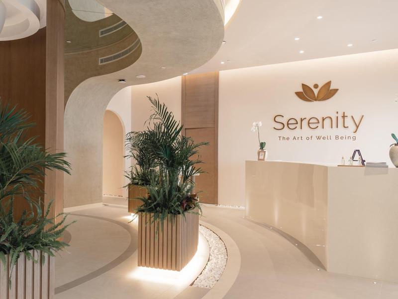 Modernes, helles Empfangsbereich mit Pflanzen und geschwungenen Linien in Beige- und Weißtönen.