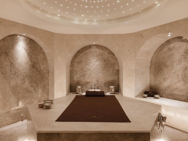 Luxuriöser, runder Spa-Raum mit runden Nischen und gedämpfter Beleuchtung.