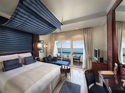 Luxuriöses Hotelzimmer mit großem Bett, Meerblick und elegantem Interieur.