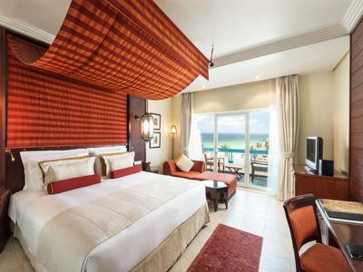 Modern eingerichtetes Hotelzimmer mit Doppelbett, Balkon und Meerblick.