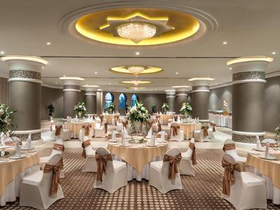 Eleganter Bankettsaal mit rund gedeckten Tischen und Blumenarrangements für ein festliches Event.