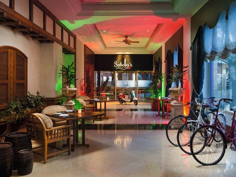 Heller Hotel-Eingangsbereich mit Sitzgelegenheiten, Fahrrädern und Pflanzen in modernem Design.